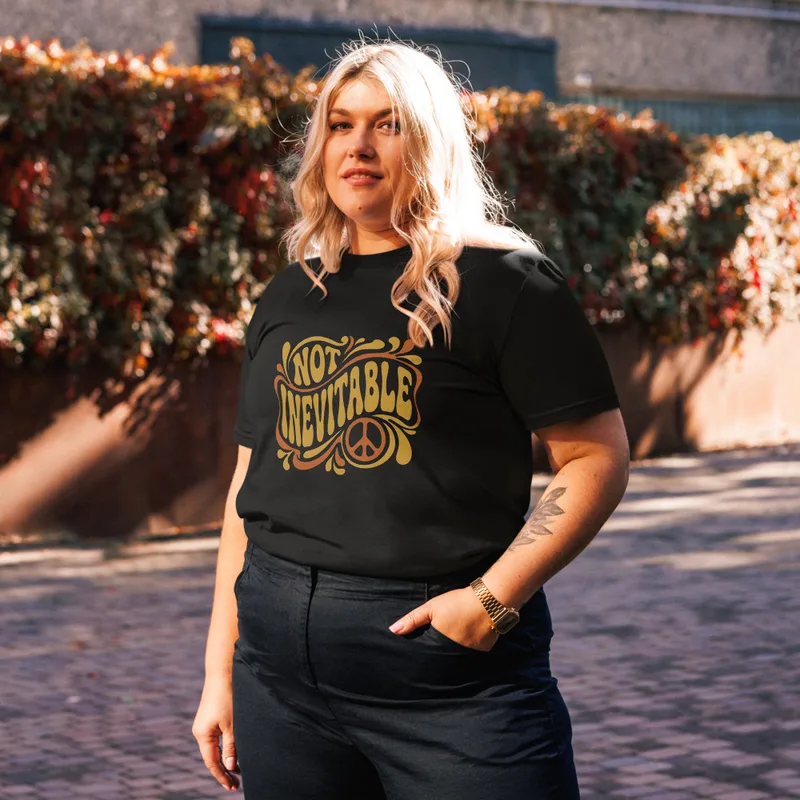Black Not Inevitable Peace Retro Tee, front view — bold 70s psychedelic lettering reading Not Inevitable with a peace