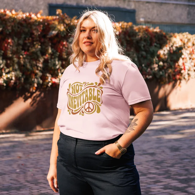 Cotton Pink Not Inevitable Peace Retro Tee, front view — bold 70s psychedelic lettering reading Not Inevitable with a peace
