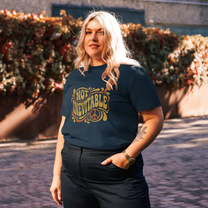 French Navy Not Inevitable Peace Retro Tee, front view — bold 70s psychedelic lettering reading Not Inevitable with a peace