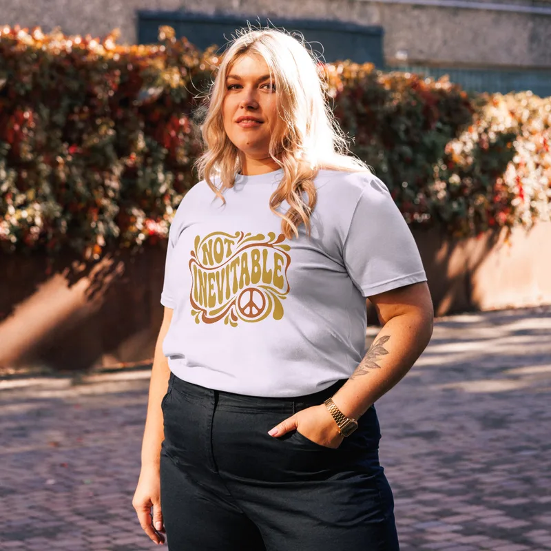 Lavender Not Inevitable Peace Retro Tee, front view — bold 70s psychedelic lettering reading Not Inevitable with a peace
