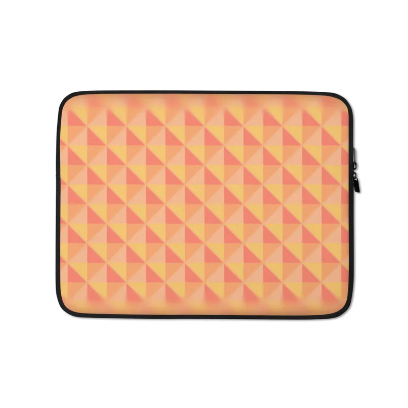 Warm Geometry Laptop Sleeve — tessellating triangles in coral red, golden yellow, and soft peach with a blurred vignette