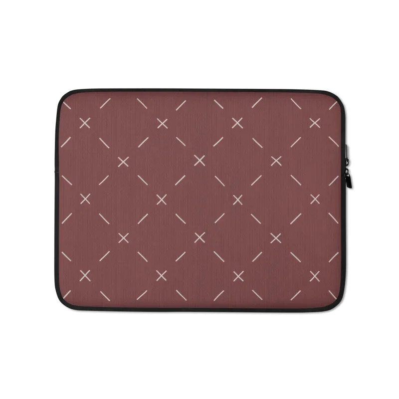 Crimson Cross Stitch Laptop Sleeve — repeating white cross and dash stitch motifs scattered across a rich burgundy textured