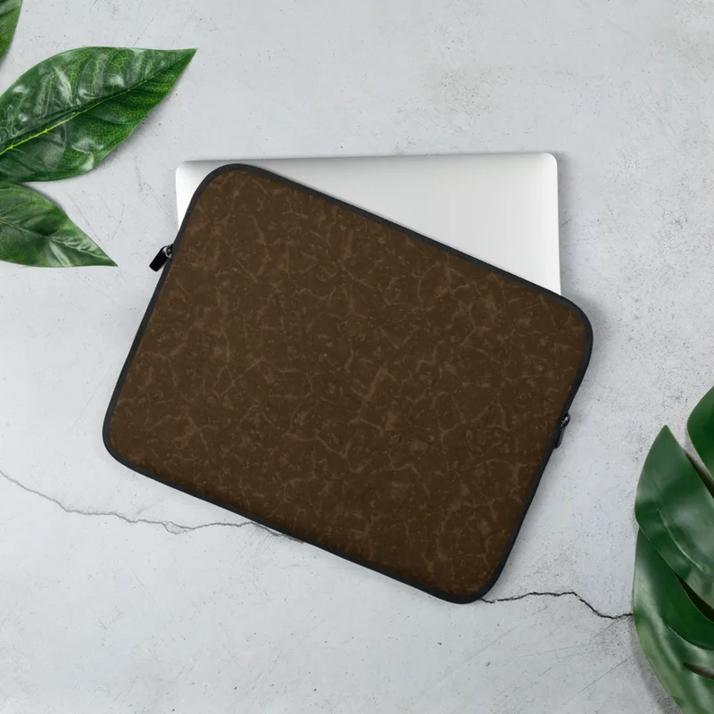 Cracked Earth Brown Terrain Laptop Sleeve — dark brown cracked earth surface with fine lighter brown fissure lines forming