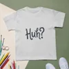 Ash Huh? Say That Again, front view — bold hand-lettered word Huh followed by a question mark in dark navy blue on a warm